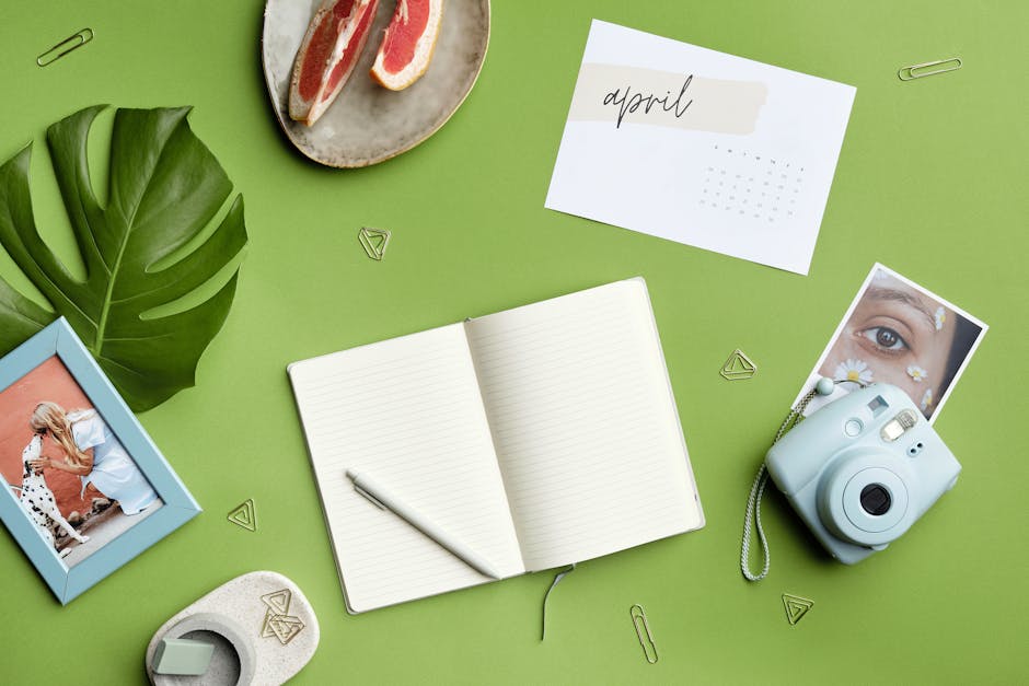 Flat lay of creative workspace with journal, instax camera, and grapefruit. Ideal for lifestyle and productivity themes.